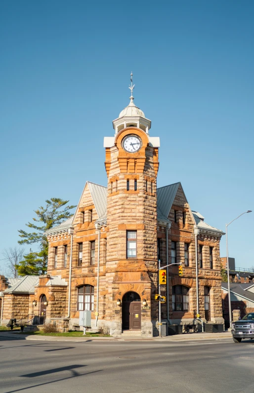 a building has a clock on it by the side of the street