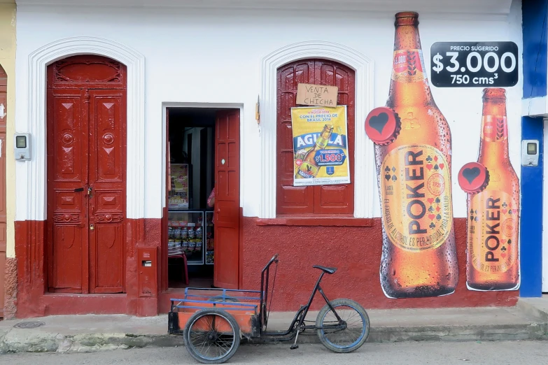 a bicycle parked in front of a building with a beer mural