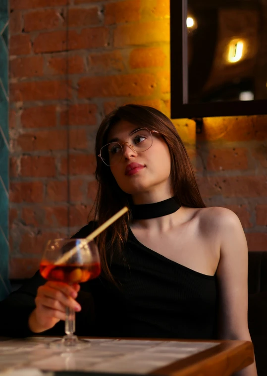 a woman sitting at a table holding a wine glass