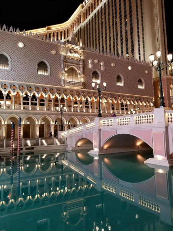 a fountain and building that is reflected in the water