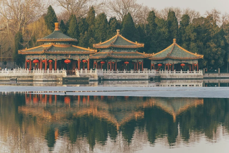 a building with four pillars, next to water