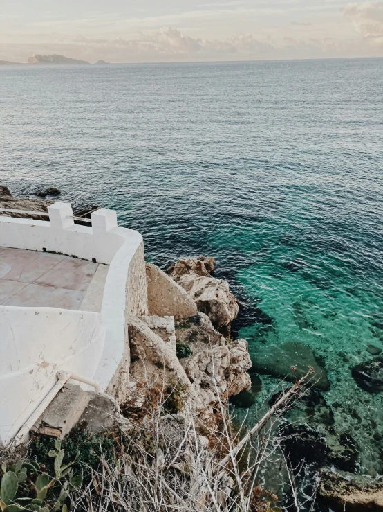 the ocean from above the cliff of an empty beach