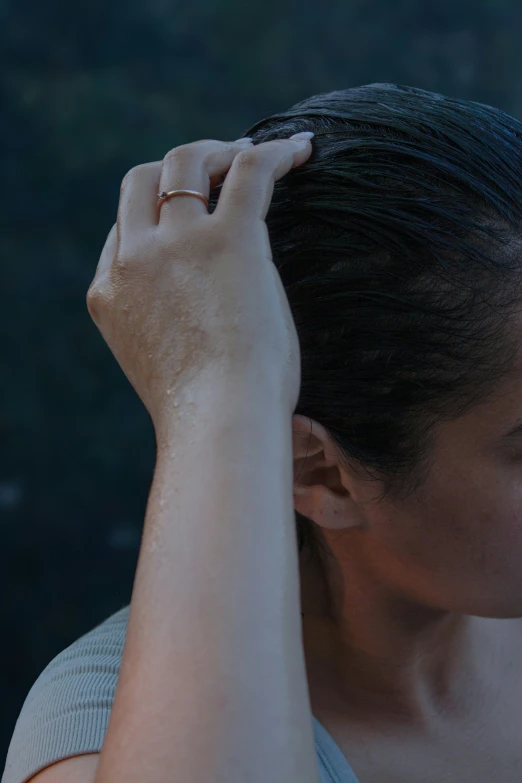 a woman is holding her hair in front of her head