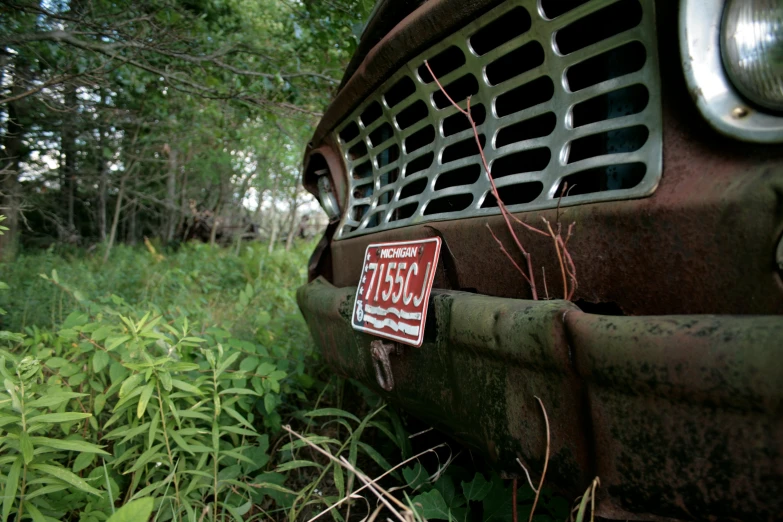 a close up of the front of an old truck in a field