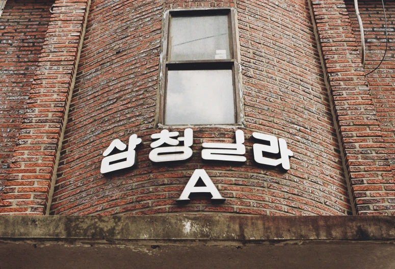 a brick building with korean letters in black and white