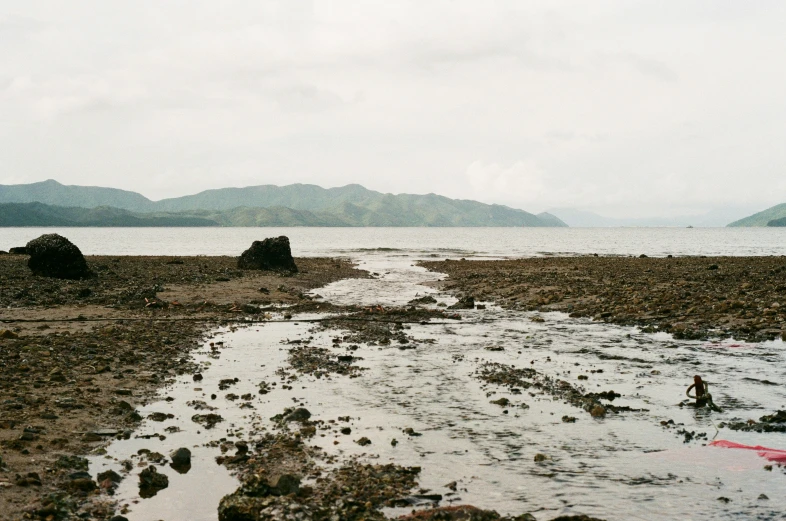 a body of water next to mountains and clouds