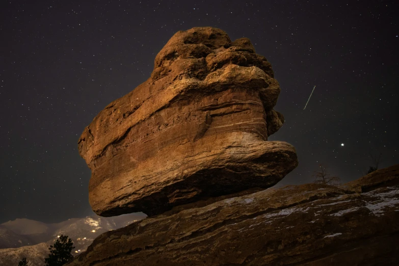 the rocks are piled up high with stars shining in the sky