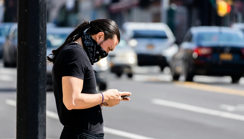 a woman holding a cell phone on the street