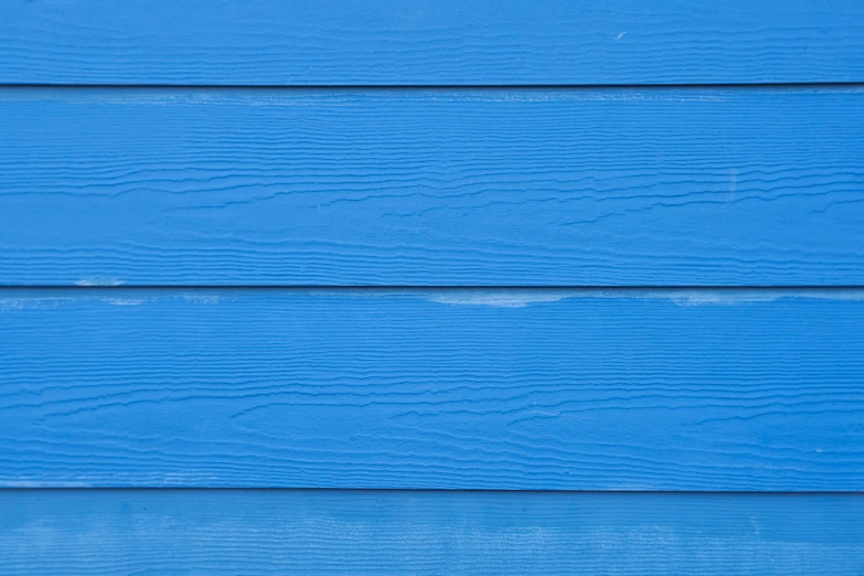 a wall of blue paint sitting on top of a wooden building