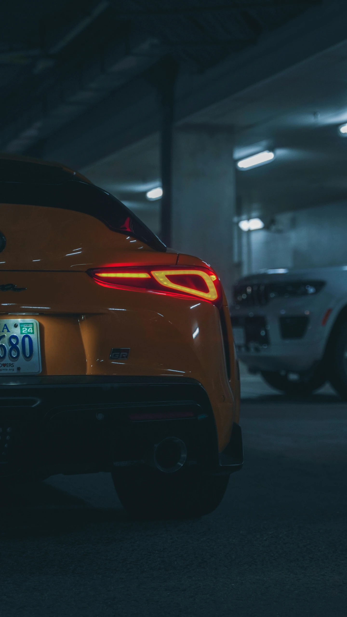 the tail lights are on a car in a parking garage