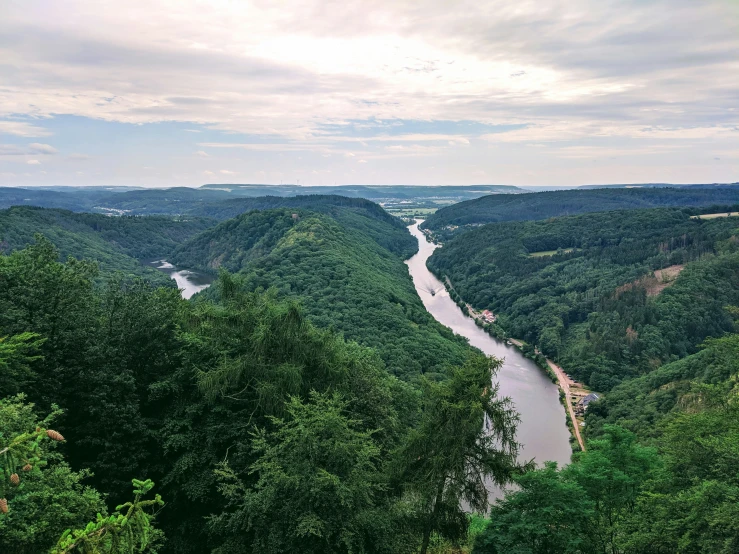 a river is shown next to green mountains