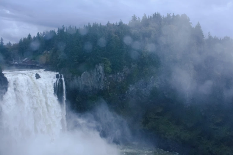 water falling into a body of water surrounded by forest