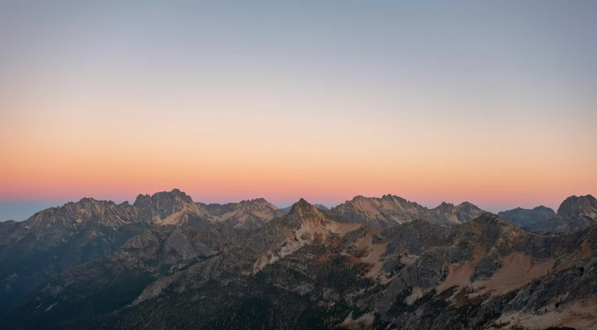 a mountain side view with the moon in the sky