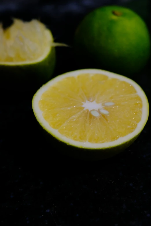 there is a lemon cut in half and another cut lime