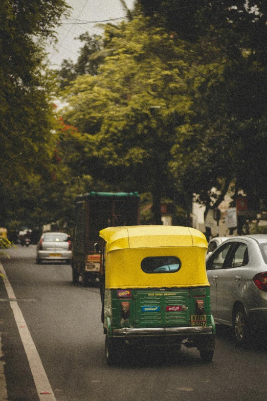 a tuk tuk carrying a small child drives down the street