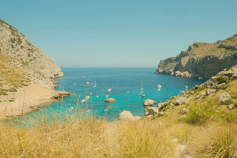 a body of water surrounded by mountains with boats