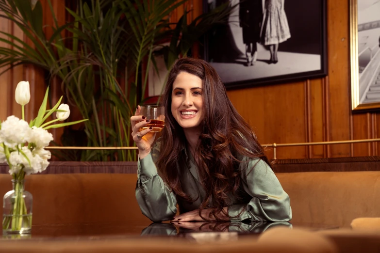 a woman smiles while holding a glass of wine