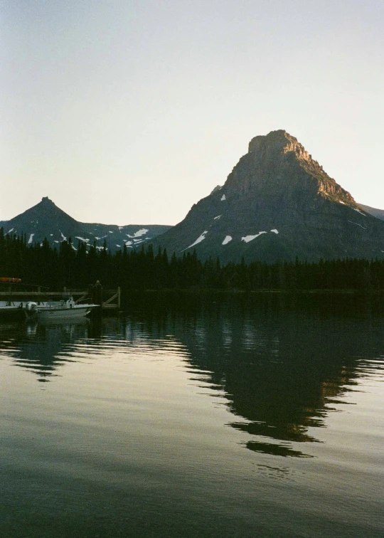 a small boat on a large lake near some mountains