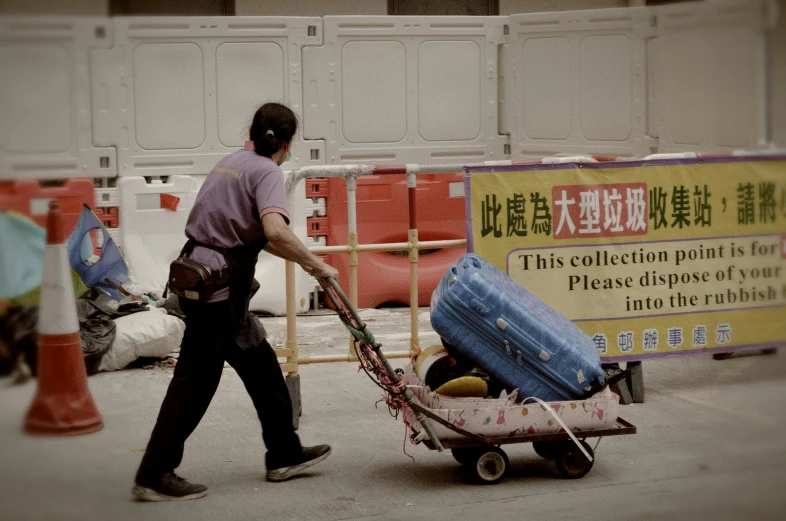 a man pulling a dolly with pieces of luggage on it