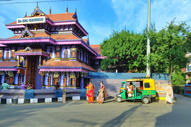 three ladies walking past a building with colorful architecture