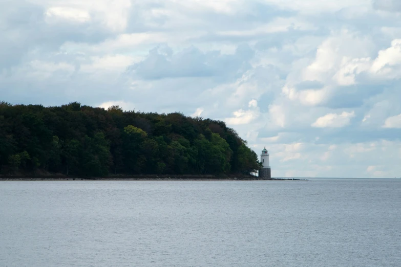 there is a lighthouse in the distance as it sits on a body of water