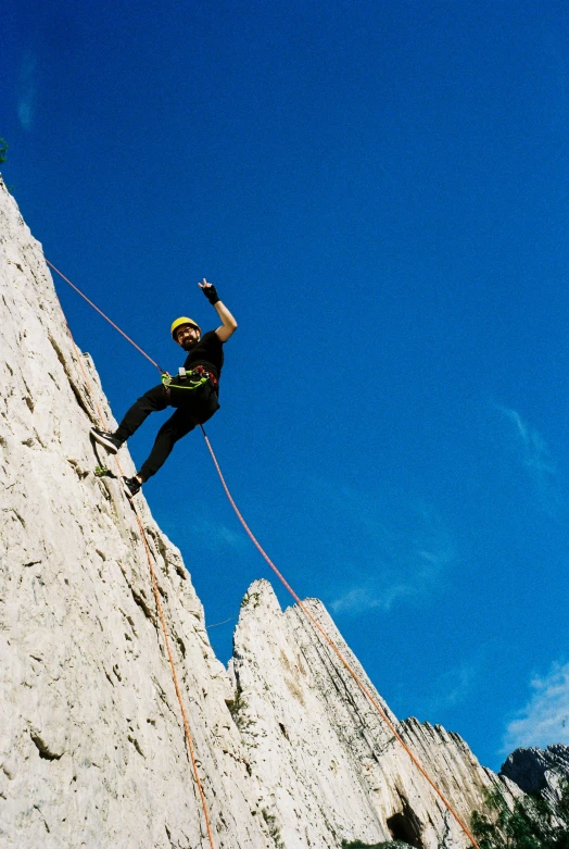 a man is on the rope on top of a rock