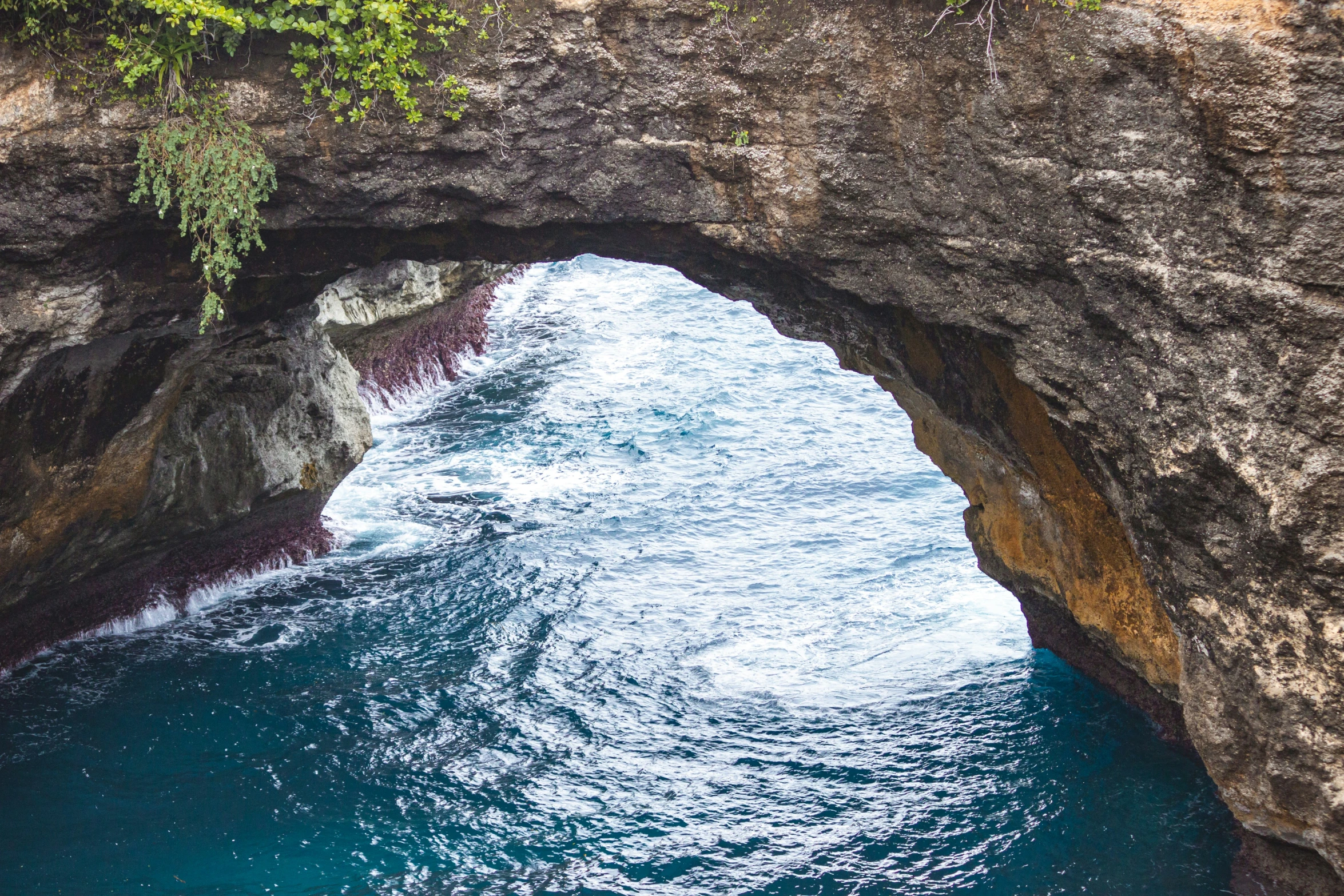 the water beneath the arched bridge is very blue