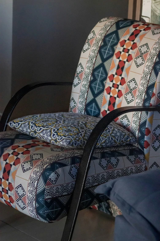 a pair of chair cushions sit on a metal arm rest