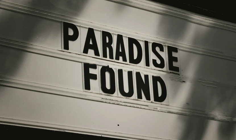 a large metal sign reading paradise found on it