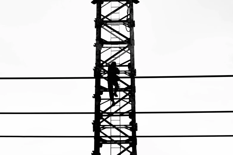 a telephone tower with a street light and telephone wires