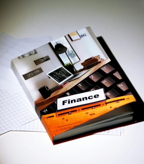 there is a finance book with a calculator and pen sitting on it