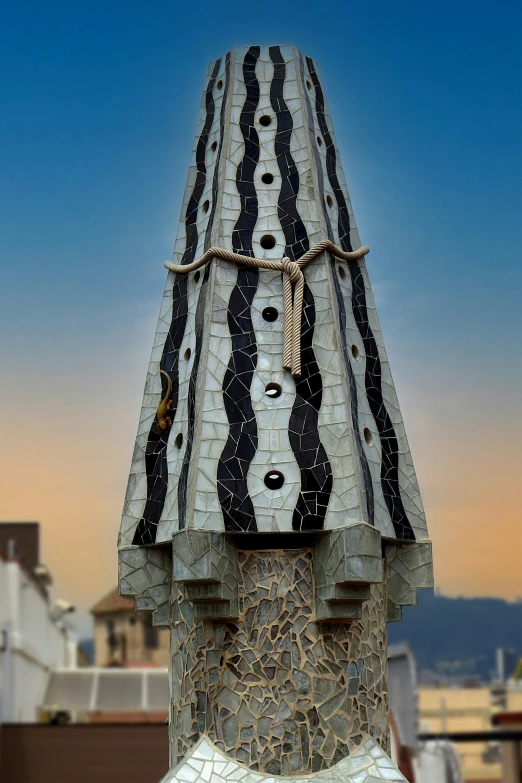 a sculpture sitting on top of a roof covered in black and white stripes