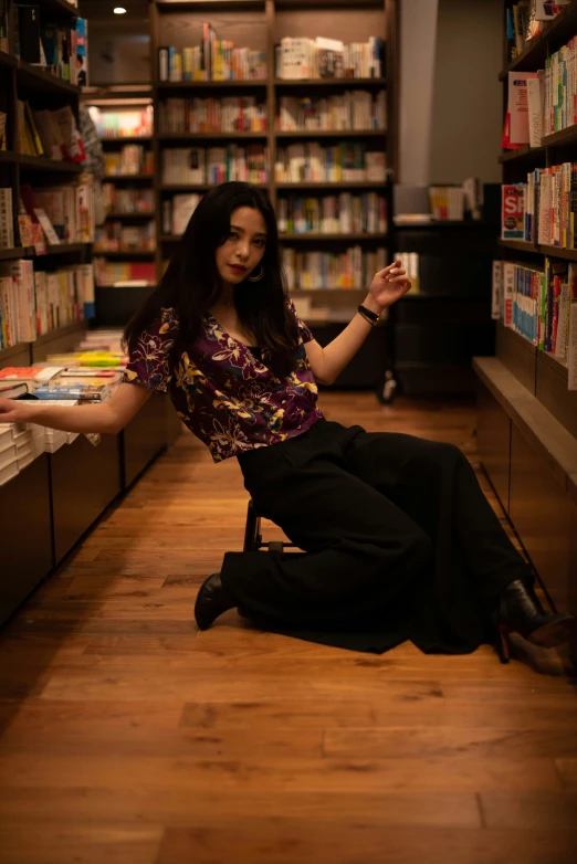 a woman is sitting on the floor in a book store