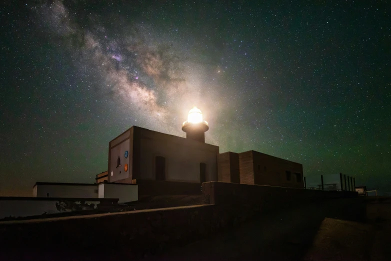 a lighthouse is lit up by the sky
