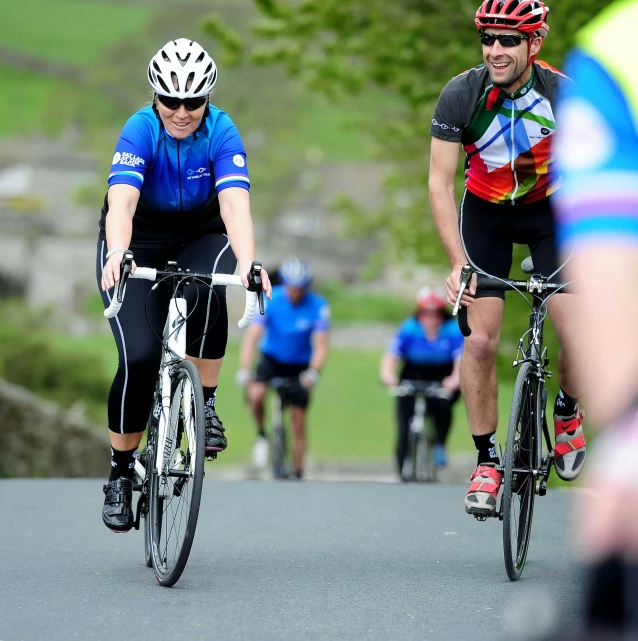 three people are riding bikes on the road