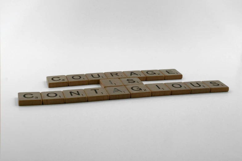 three scrabble tiles spelling out words on a white surface