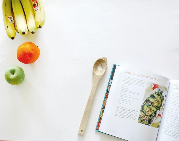 some fruits and an empty spoon sitting on a table