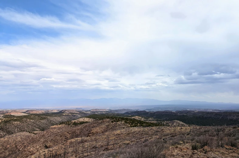 a view of the top of a hill with clouds