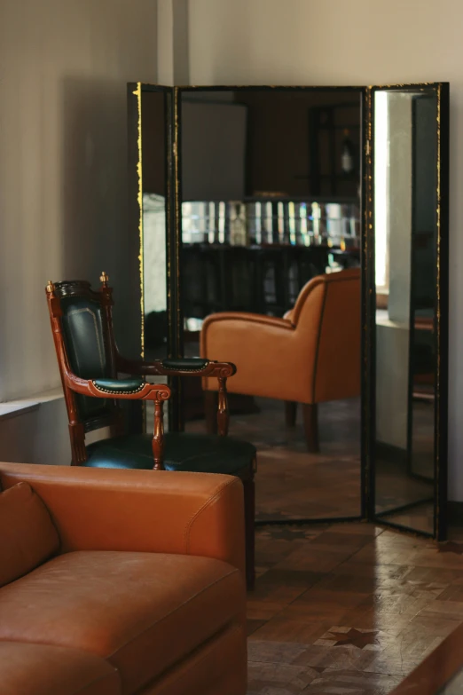 a living room with large mirror, couch and chairs