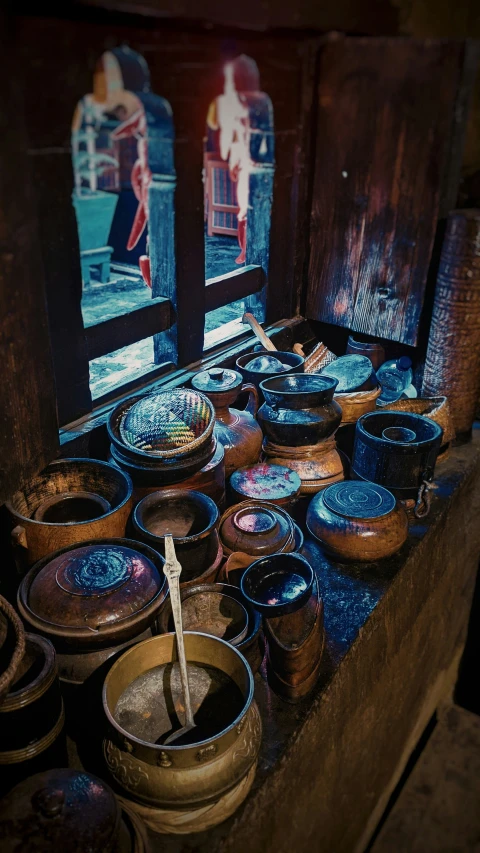 old buckets are lined up in front of a window