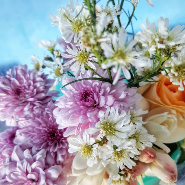 several flowers in a glass vase with water on the side