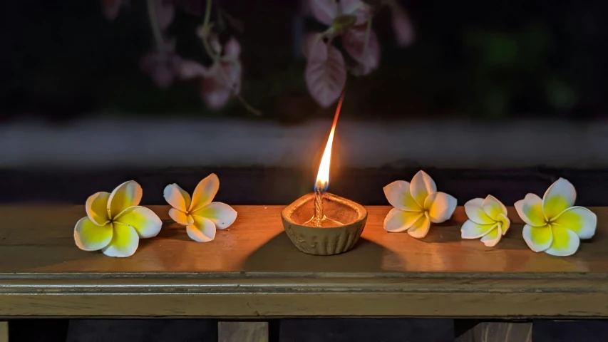 some flowers and a candle that is lit