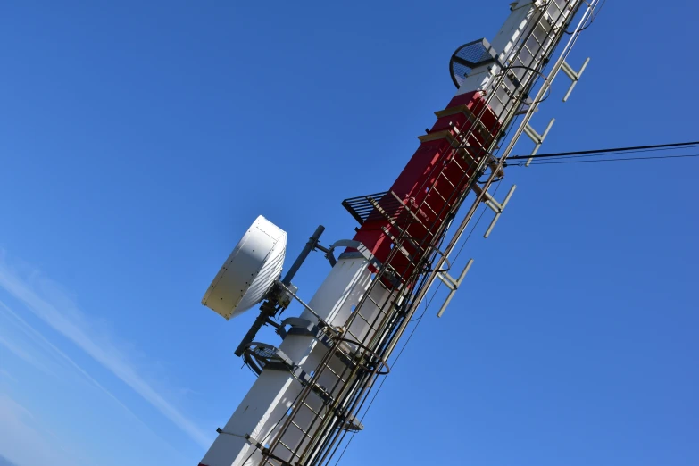 a telephone tower with multiple red and white boxes