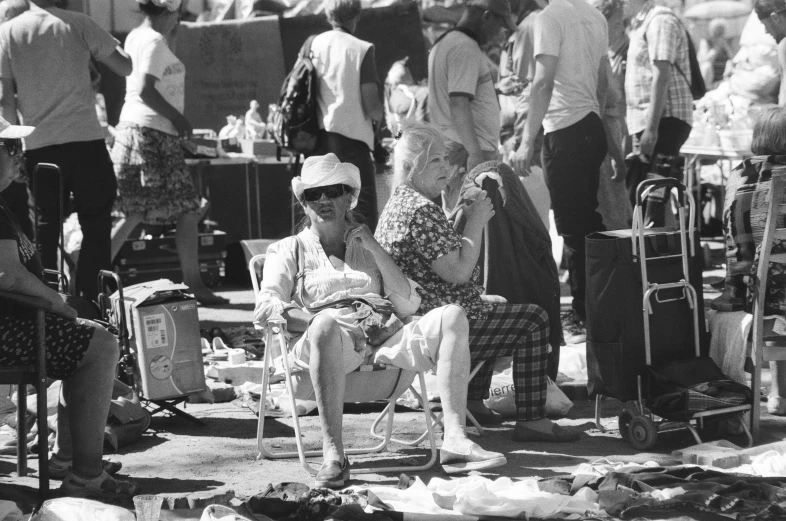 a woman sitting in a chair and another woman standing next to her