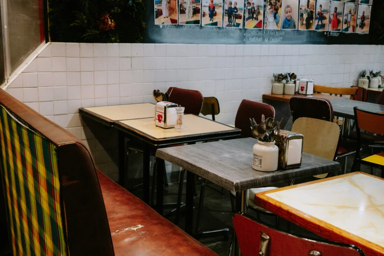 a restaurant filled with tables and chairs next to pictures on the wall