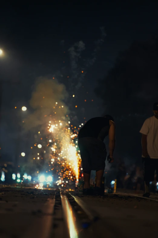 fireworks in the street during a celetion with people walking by