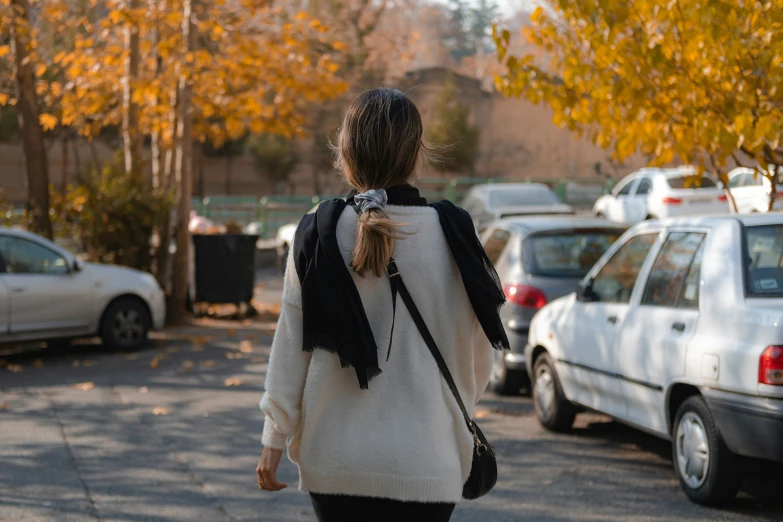 a woman is walking down the street with her backpack