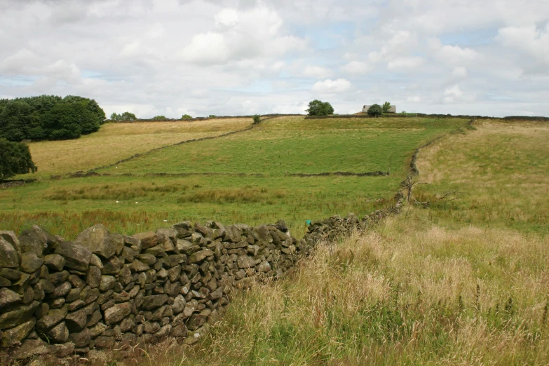 there is a rock wall by a field