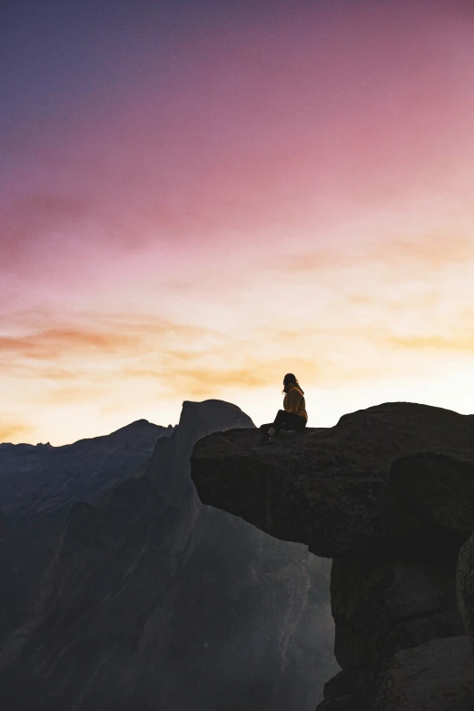 someone sitting on top of a mountain overlooking the horizon