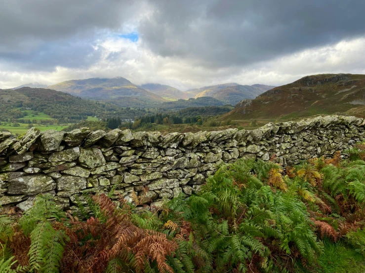 a stone wall on the side of a field